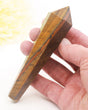 Natural Tiger Eye crystal wand 129g with golden brown chatoyant bands and gold display stand, polished 12.6cm Tiger Eye point.