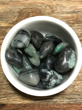 Emerald tumbled stone in deep green tones — crystal of love, wisdom, and heart healing