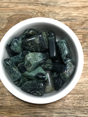 Kambaba Jasper tumbled stone with green and black fossil-like patterns — crystal of peace, grounding, and ancient wisdom.