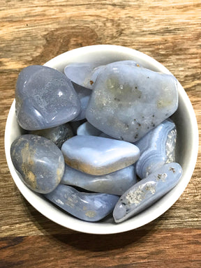 Chalcedony tumbled stone in soft blue-white tones — crystal of harmony, compassion, and emotional balance.