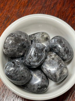 Larvikite tumbled stone with silver-blue flashes — crystal of grounding, protection, and transformation.