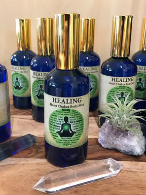 Healing Chakra Mist in a 100ml glass bottle with gold atomiser, infused with Lavender, Mandarin, Cedarwood, Bergamot, Clary Sage, and Vetiver oils, crystal-charged and Reiki-activated by Inspired By 3.